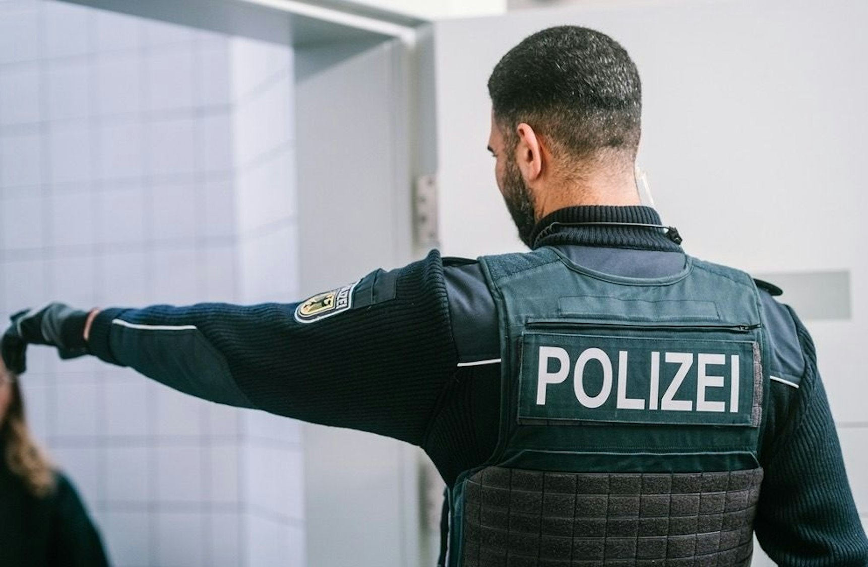 Zwei Bundespolizisten führen einen Mann in Handschellen ab.