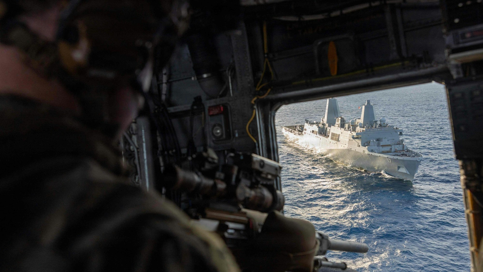 Dieses Foto des US Marine Corps wurde am 25. November 2025 aufgenommen. Es zeigt einen US-Marine, der während eines Einsatz-Trainings an Bord des amphibischen Transportdocks USS San Antonio in der Karibik aus einem Hubschrauber Luftunterstützung leistet.