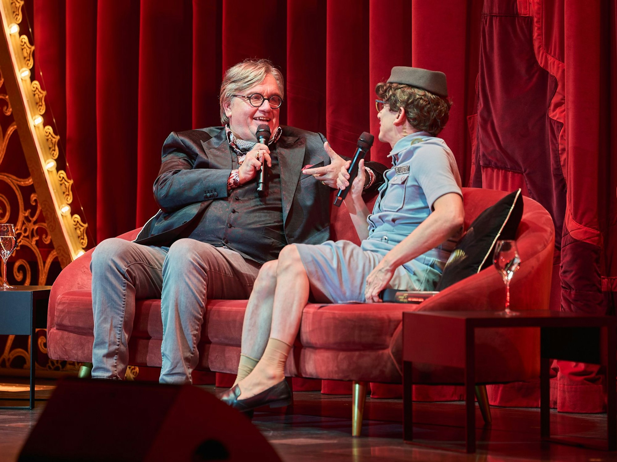 Hape Kerkeling spricht mit Erika Laste auf einem Sofa.