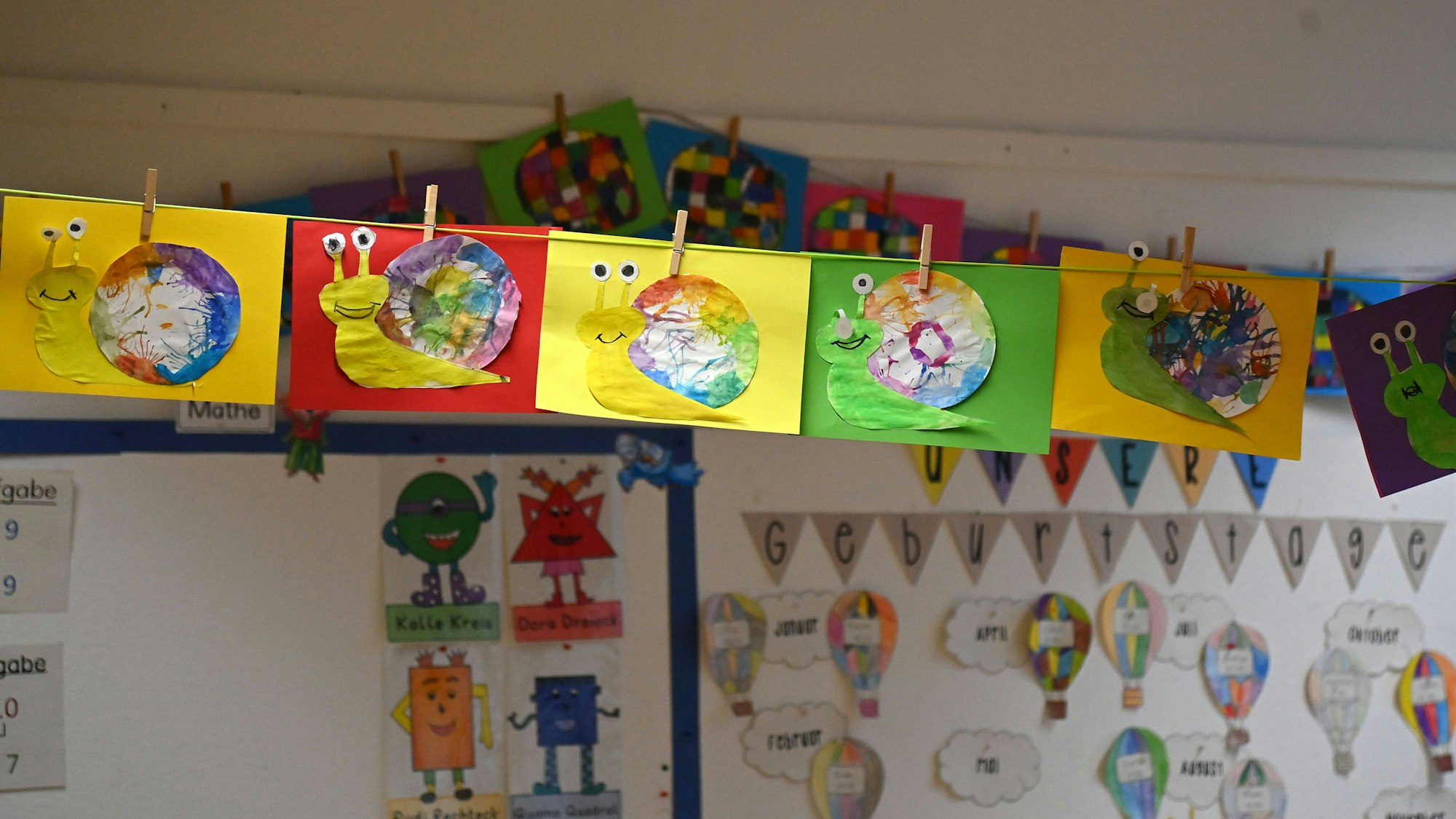 Bunte Schnecken-Kunstwerke und Geburtstagskalender im Klassenzimmer