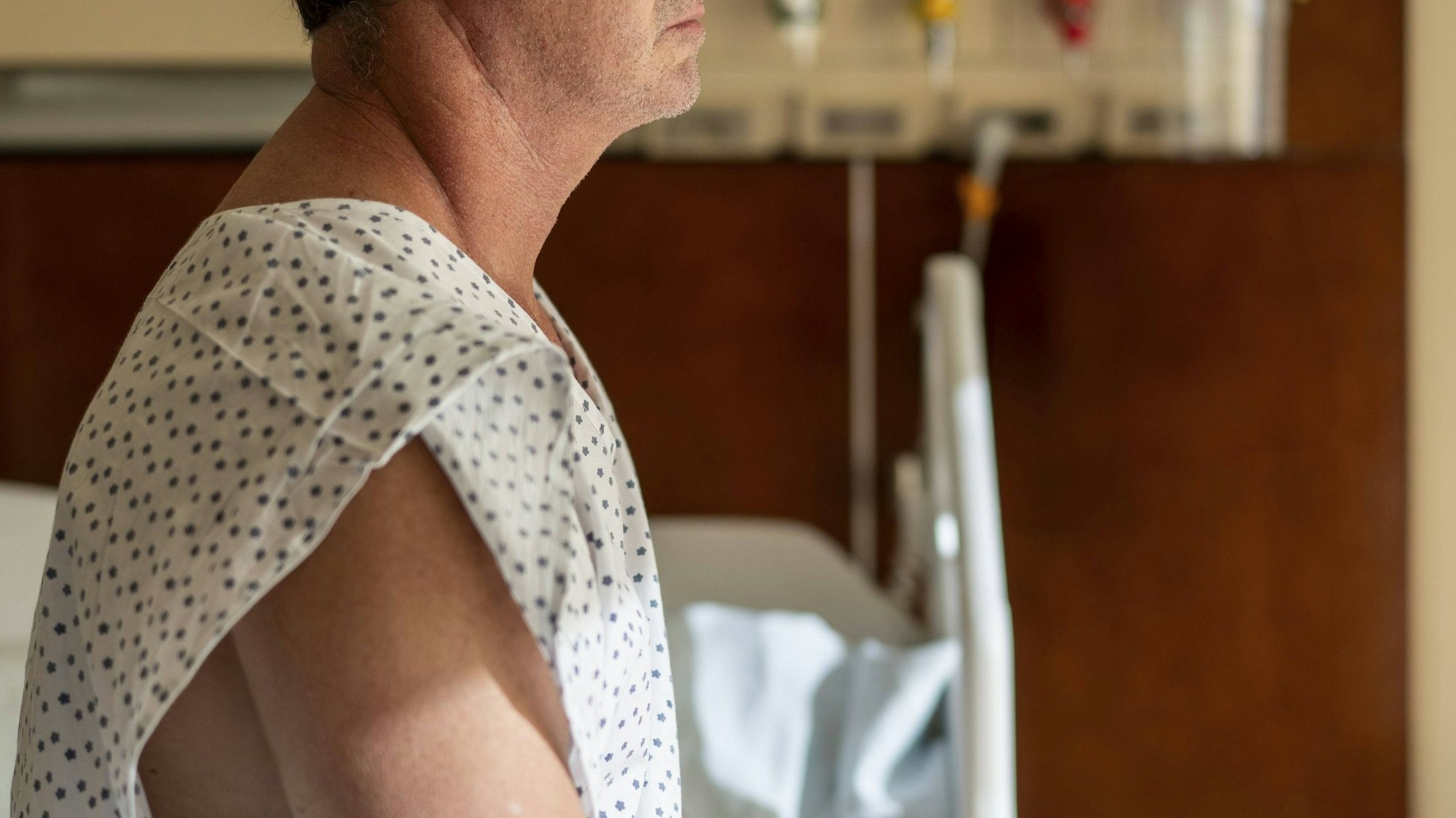 Patient sitzt nachdenklich in einem Krankenhausbett.