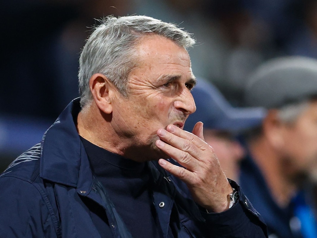 Klaus Allofs fasst sich an den Mund.