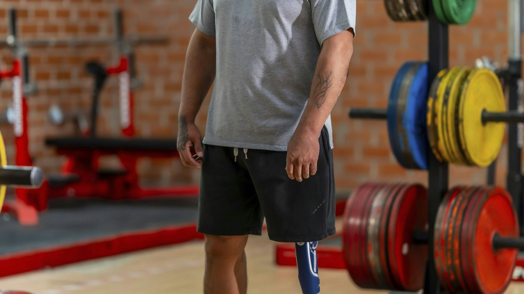 Mann mit Beinprothese steht im Fitnessstudio.