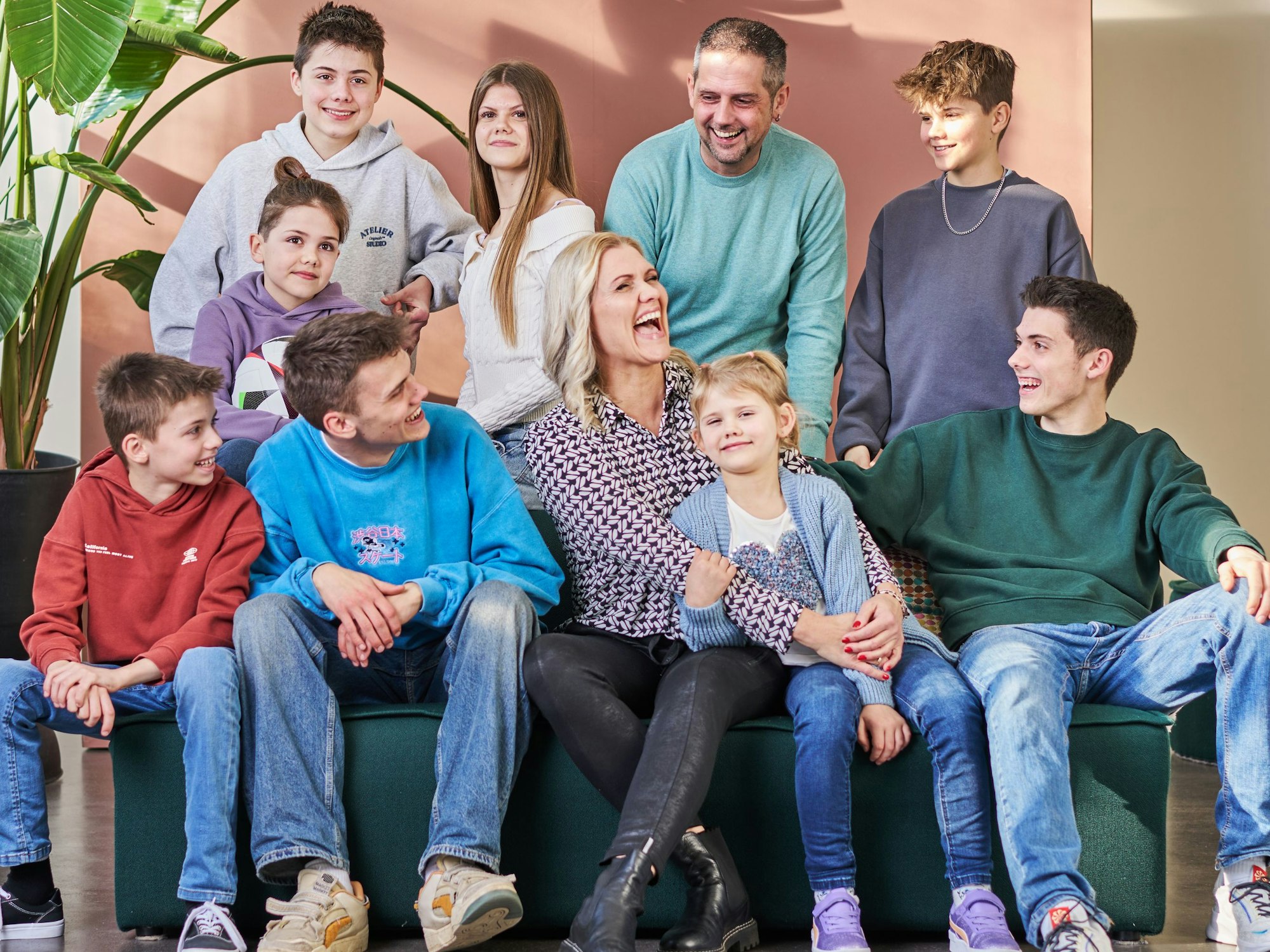 Eine fröhliche Familie mit acht Kindern hat sich zum Gruppenfoto versammelt