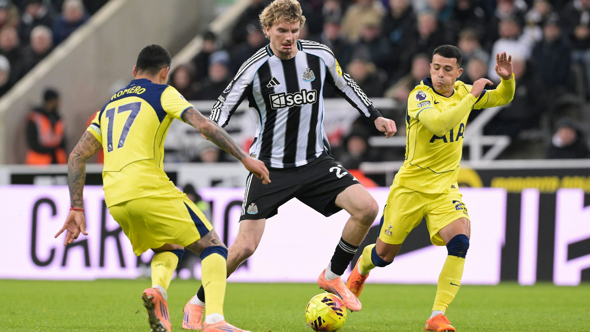 Nick Woltemade (M.) dribbelt den Ball, während Pedro Porro und Cristian Romero ihn aufzuhalten.
