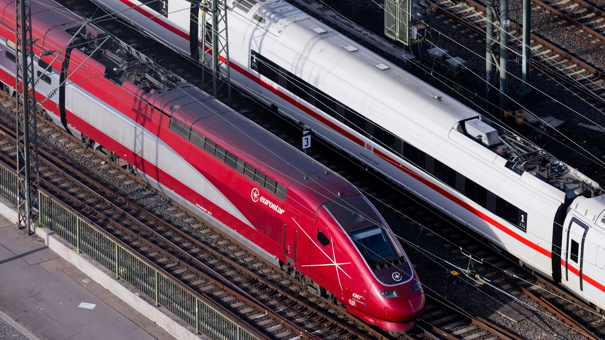 Ein ICE der Deutschen Bahn und ein Eurostar fahren über die Hohenzollernbrücke.