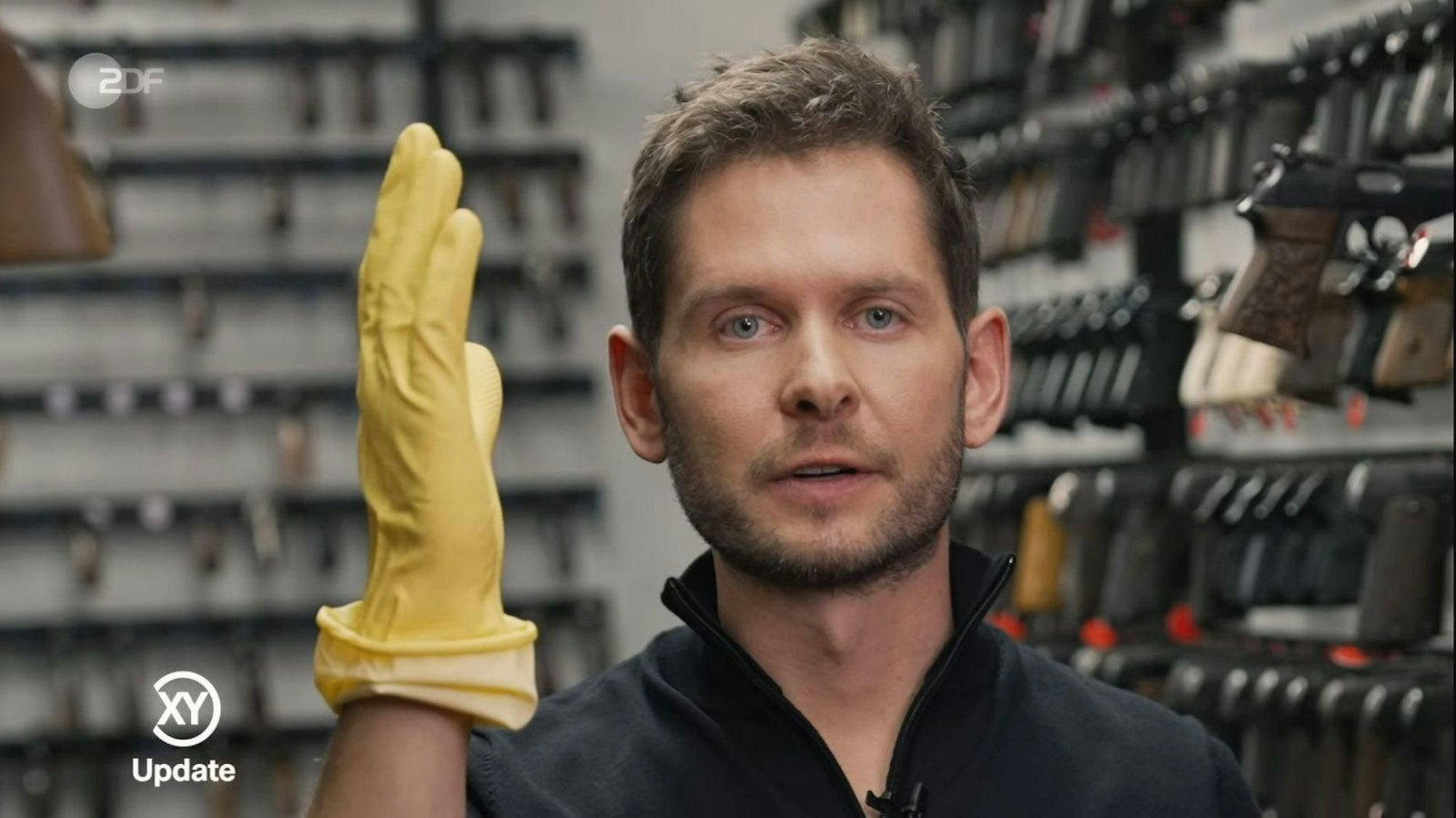 Ermittler Fabian Puchel wies in „Aktenzeichen XY ... Update“ nochmals auf die gelben Handschuhe hin, die einer der Täter beim Raubüberfall auf eine Familie getragen haben soll. (Bild: ZDF)