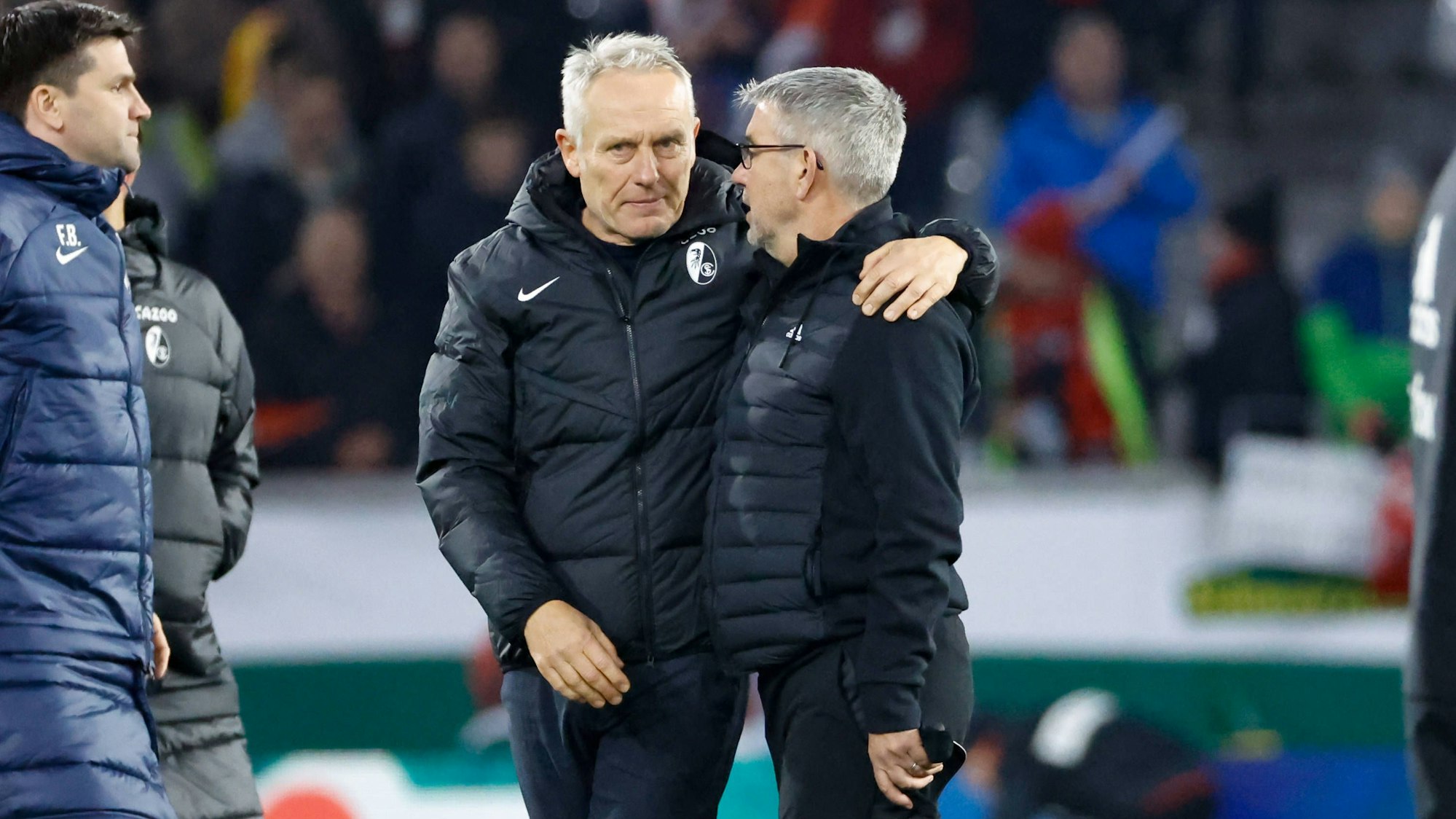 Zwei Trainer, Christian Streich und Urs Fischer, umarmen sich auf dem Spielfeld.