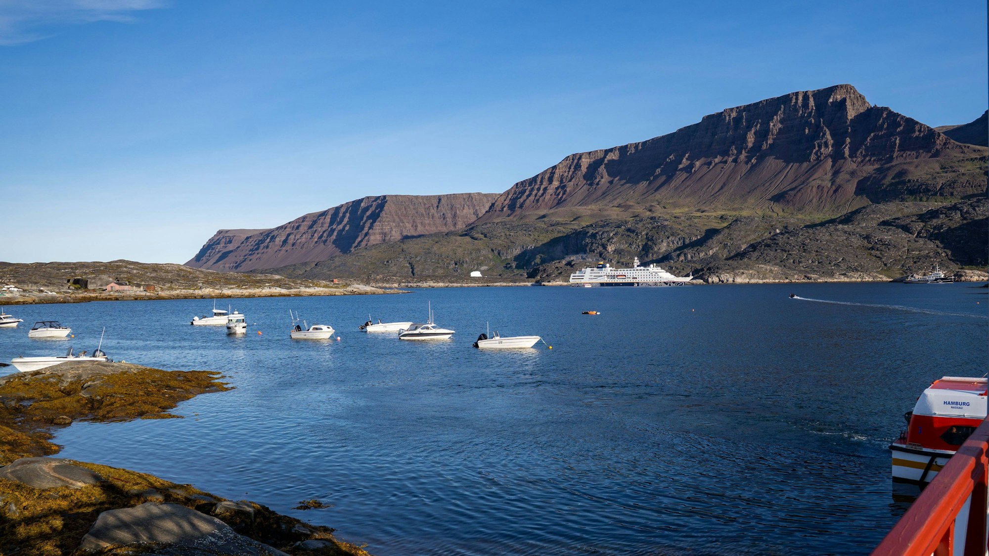 Blick auf den Hafen von Qeqertarsuaq mit kleinen Booten und der MS Hamburg