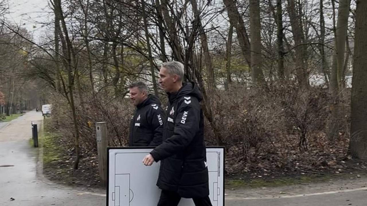 Frank Kaspari trägt eine Taktiktafel unter dem Arm, neben ihm geht Lukas Kwasniok.
