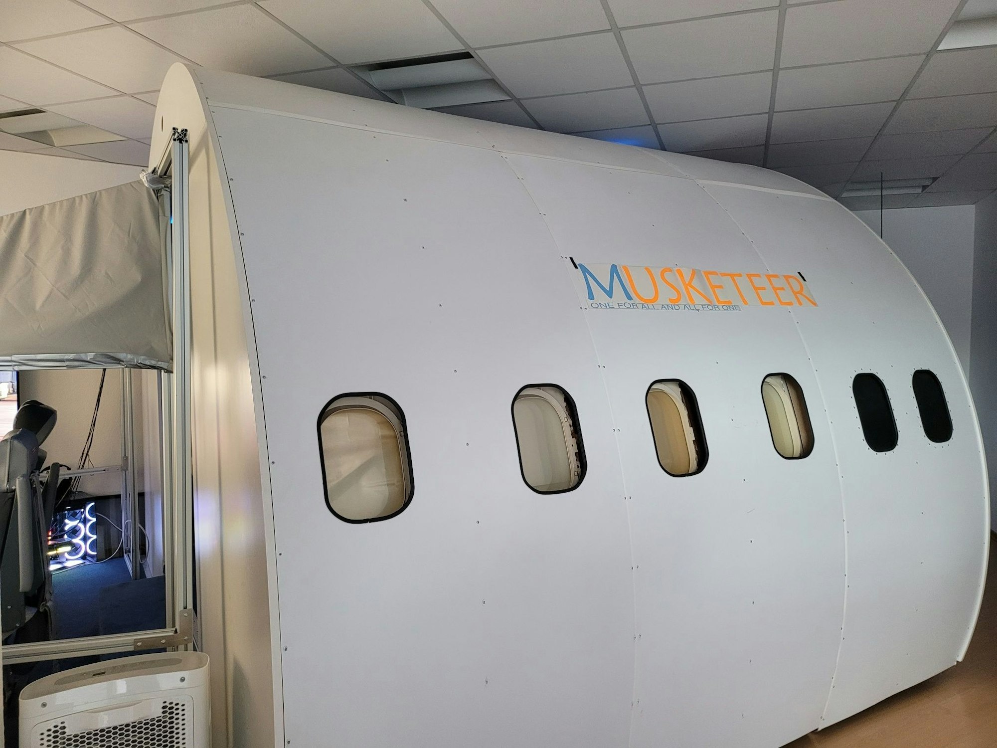 Ein Flugsimulator, dessen weiße Außenverkleidung aussieht wie bei einem echten Flugzeug.