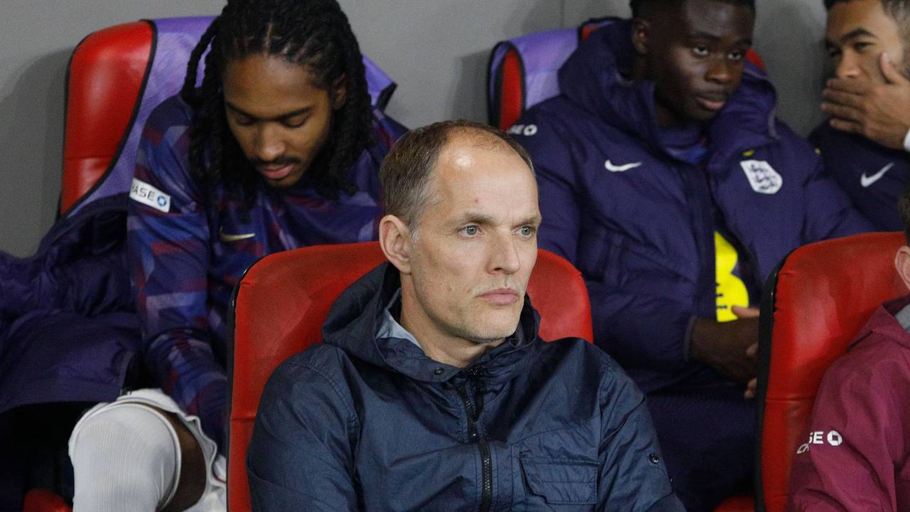 Thomas Tuchel sitzt mit verschränkten Armen auf der Ersatzbank.