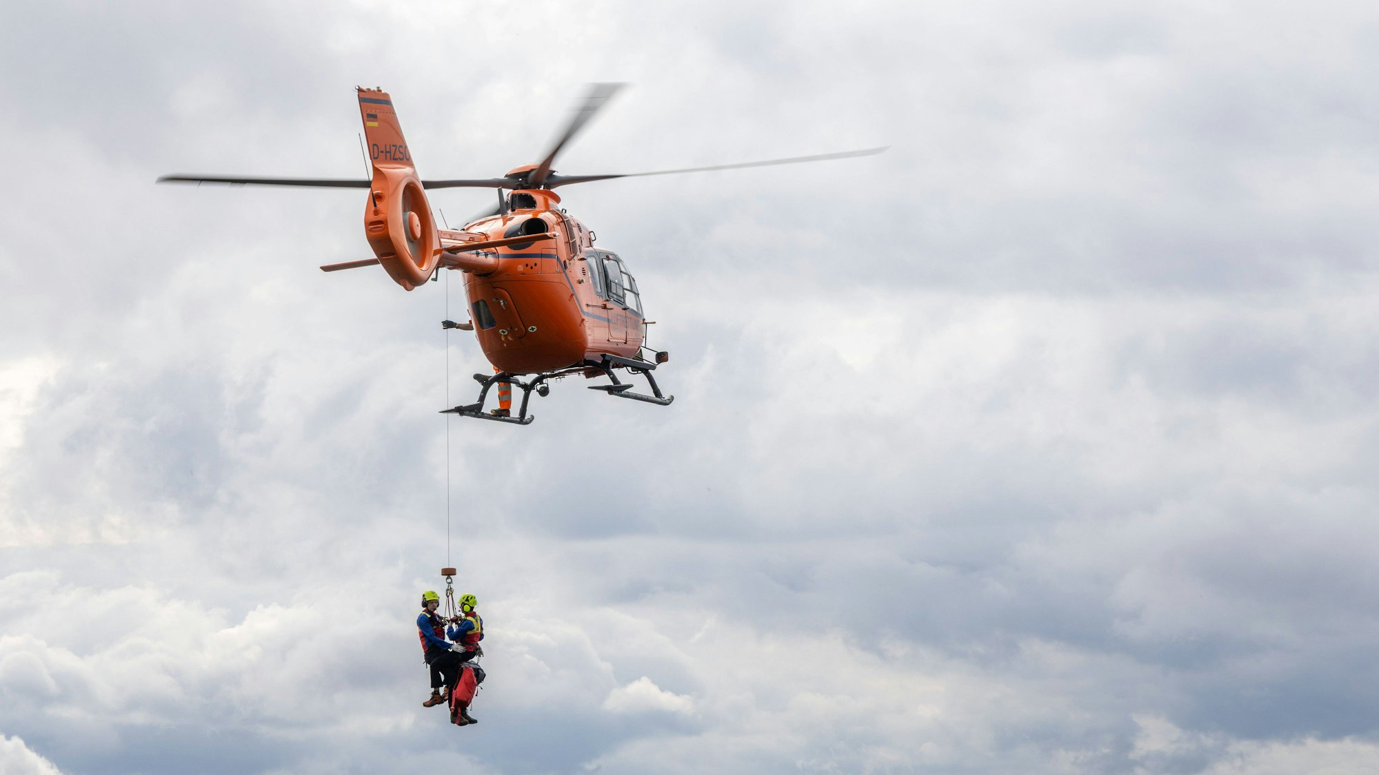 Rettungshubschrauber Christoph 14 lässt Einsatzkräfte der Bergwacht an Rettungswinde herab