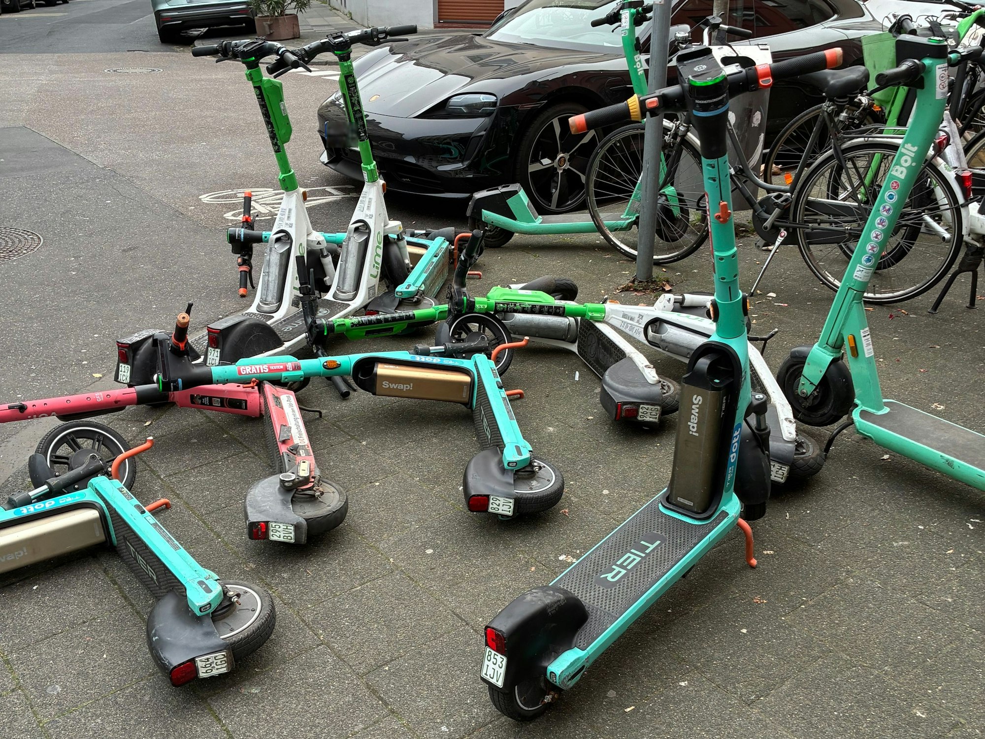 E-Scooter liegen auf dem Gehweg.