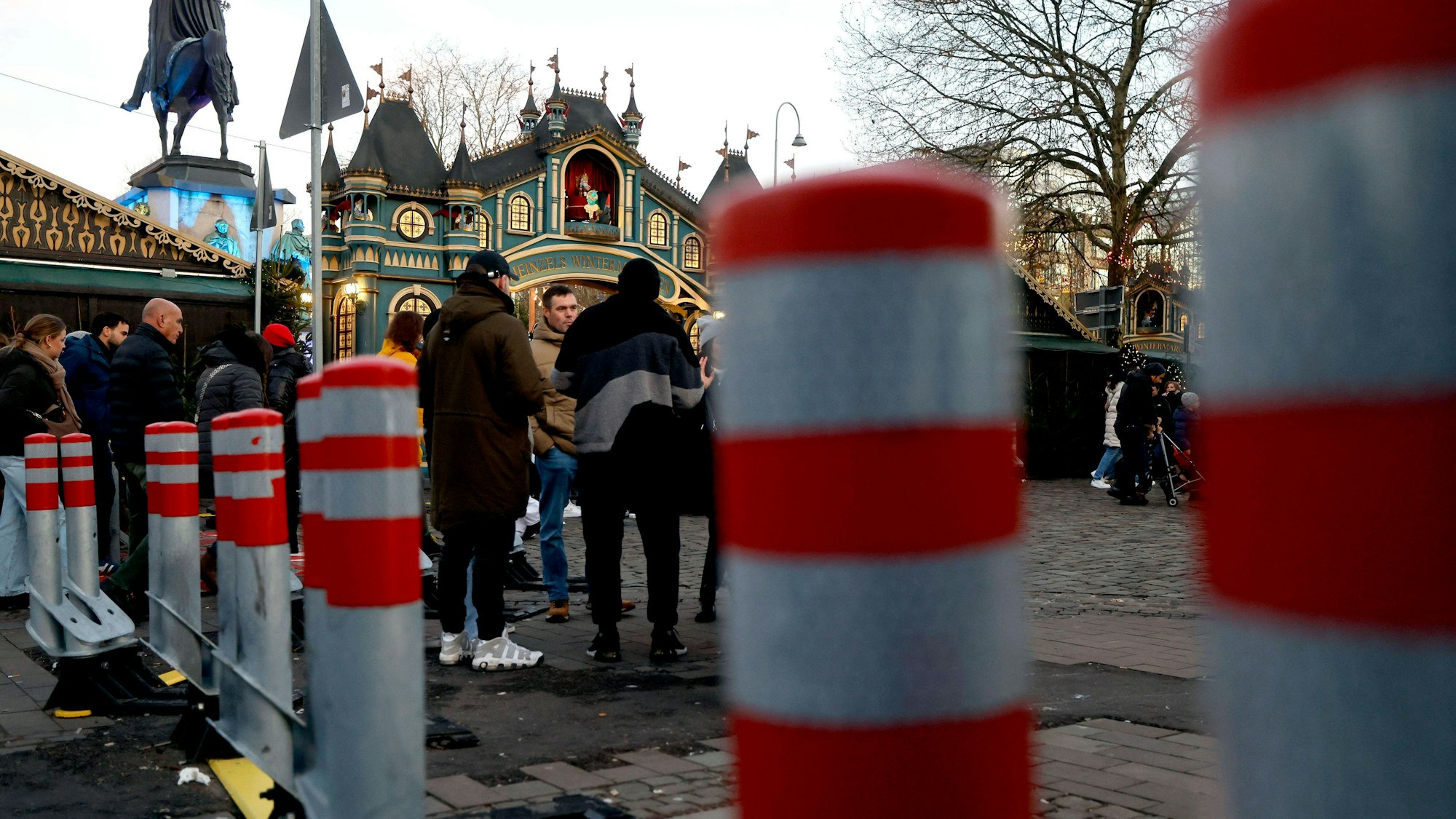 Der Kölner Weihnachtsmarkt Heinzels Wintermärchen mit Besuchern und mobilen Absperrungen