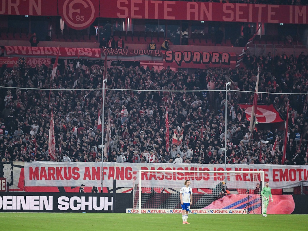 Fans von Fortuna Düsseldorf haben hinter dem Tor ein großes Spruchband platziert, auf dem steht: „Markus Anfang: Rassismus ist keine Emotion!“