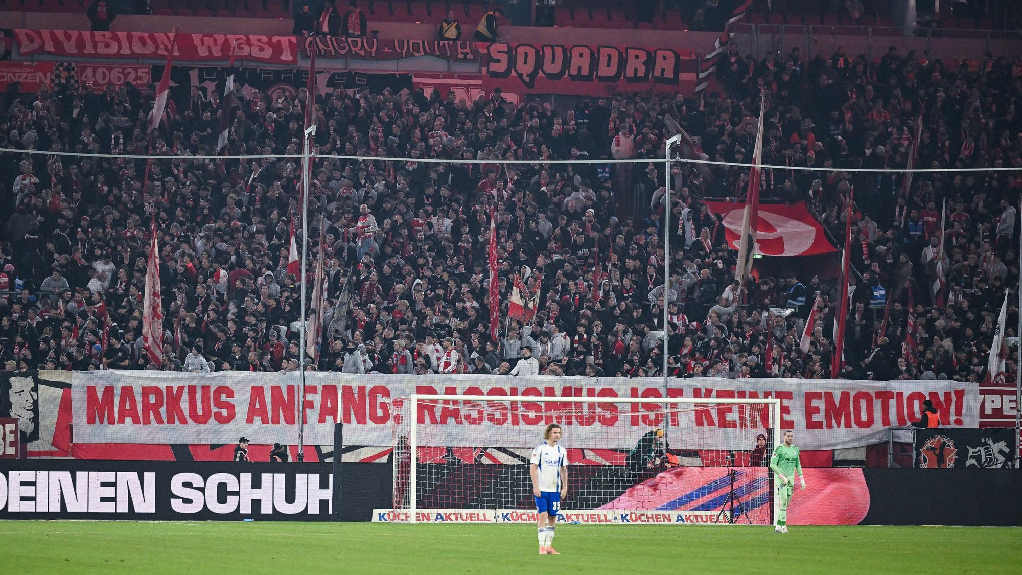 Fans von Fortuna Düsseldorf haben hinter dem Tor ein großes Spruchband platziert, auf dem steht: „Markus Anfang: Rassismus ist keine Emotion!“