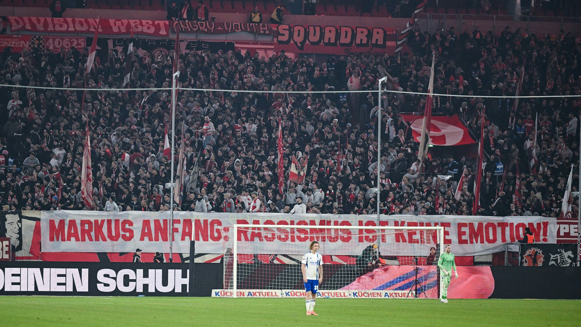Fans von Fortuna Düsseldorf haben hinter dem Tor ein großes Spruchband platziert, auf dem steht: „Markus Anfang: Rassismus ist keine Emotion!“