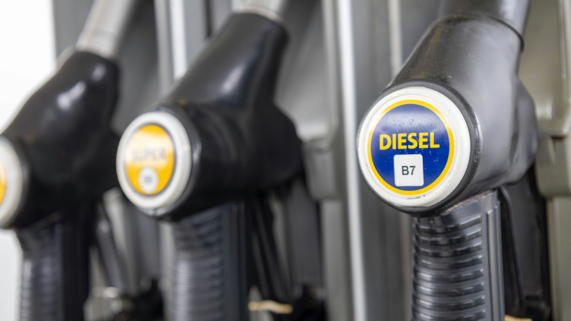 Nahaufnahme von Zapfpistolen an einer Tankstelle, darunter Diesel B7 und Super