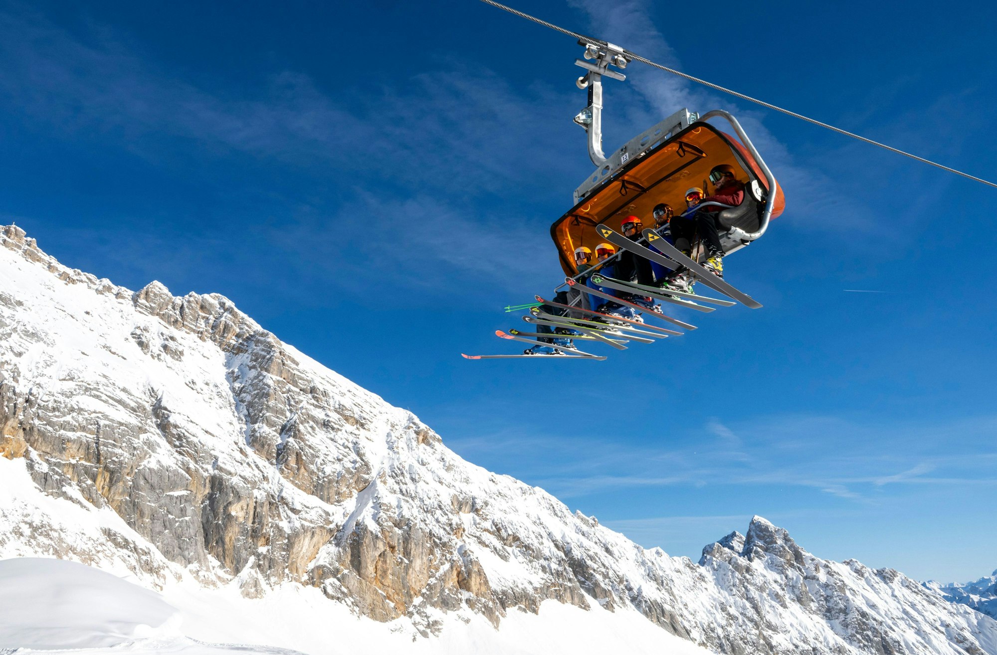 Auf der Zugspitze ist ein deutscher Alpinist ums Leben gekommen. Das Symbolfoto zeigt Skifahrer, die in einem Skilift auf der Zugspitze sitzen.