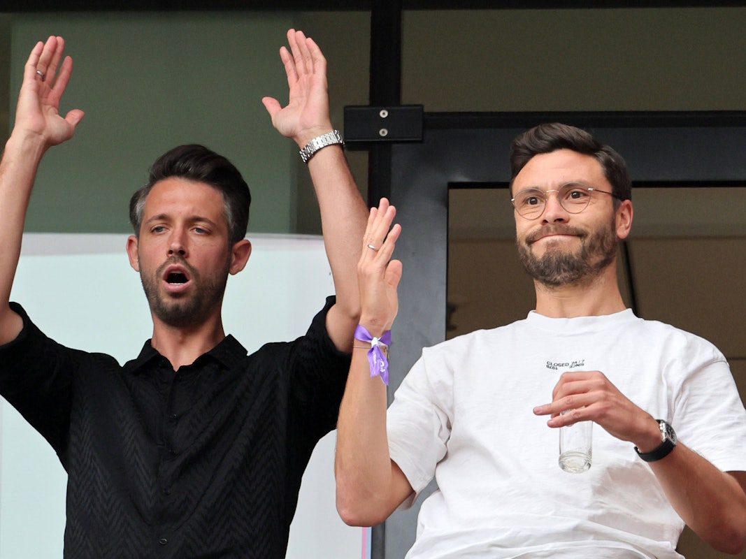 Mark Uth und Jonas Hector reagieren auf der Tribüne bei einem FC-Spieler.