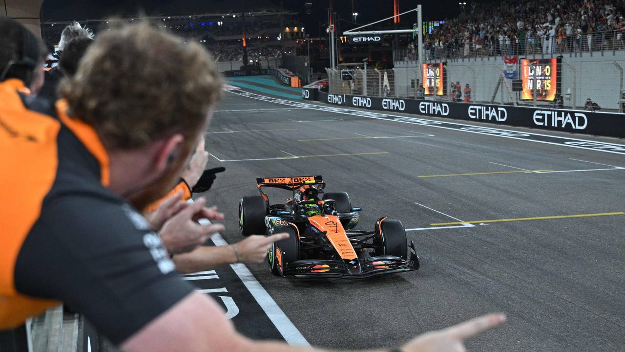 Lando Norris fährt über die Ziellinie, sein Team jubelt ihm zu.