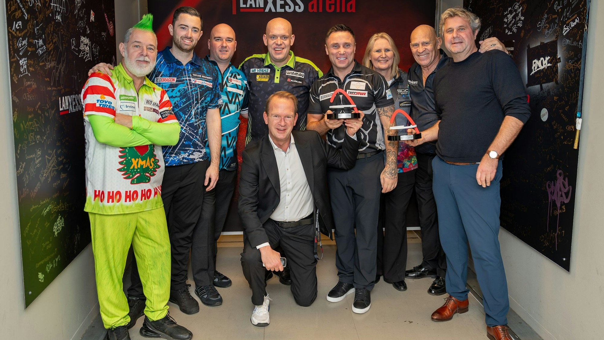 Peter Wright, Luke Humphries, Rob Cross, Michael van Gerwen, Gerwyn Price, Trina Gulliver, Russ Bray, Werner Moltke und Stefan Löcher mit dem Award.