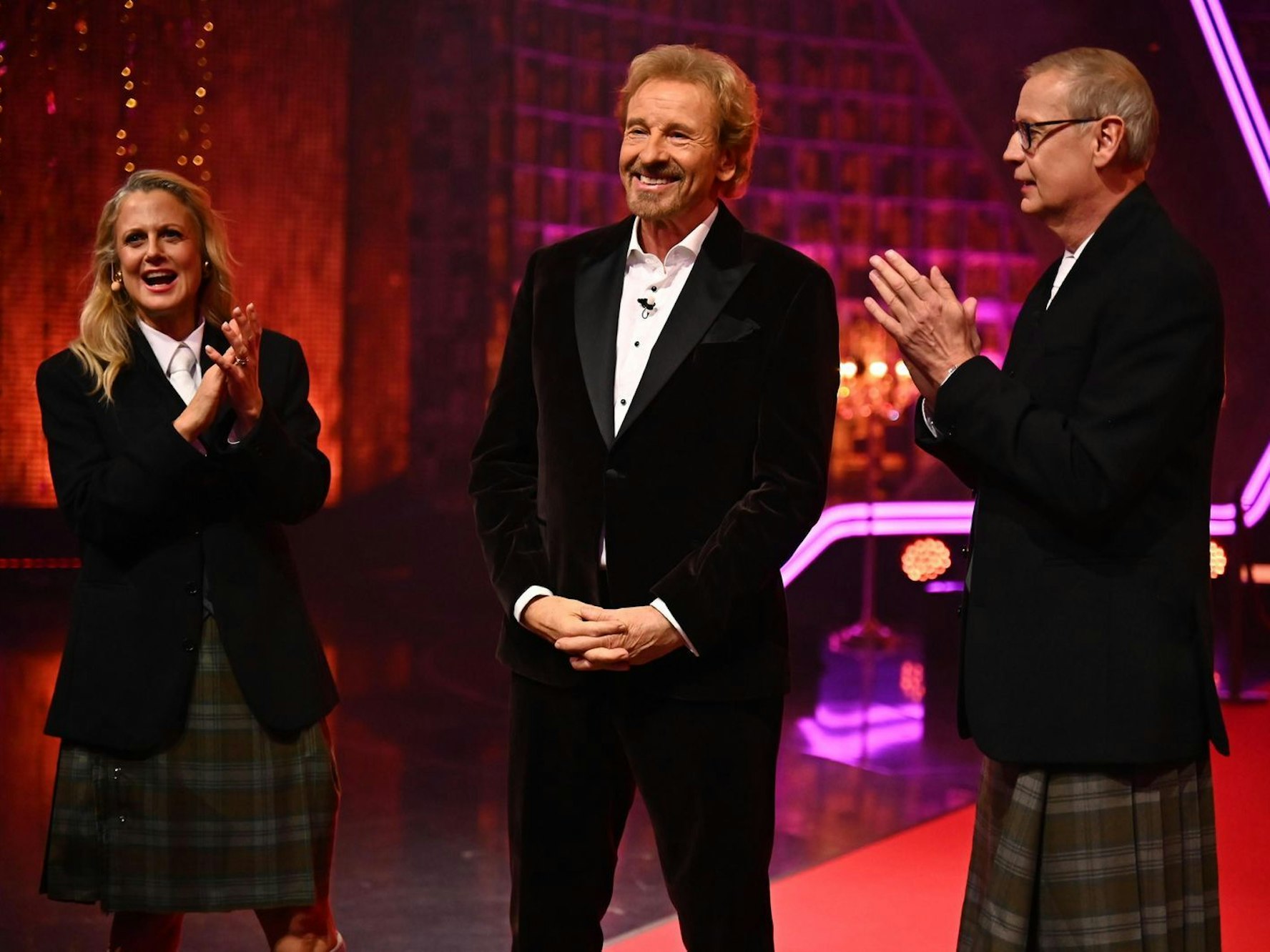 Barbara Schöneberger und Günther Jauch stehen an der Seite von Thomas Gottschalk und klatschen für ihn.