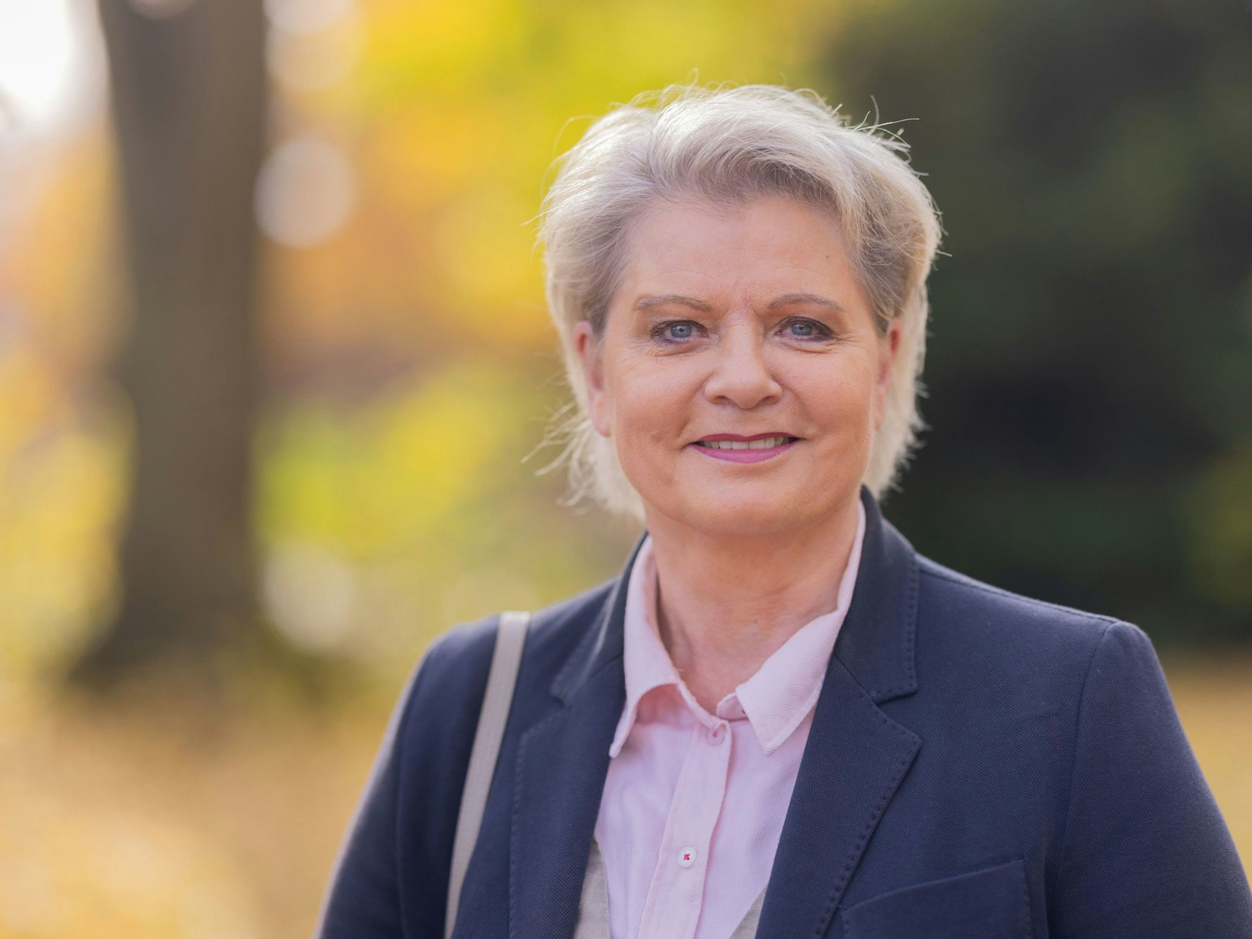 Andrea Spatzek steht in einem Park.