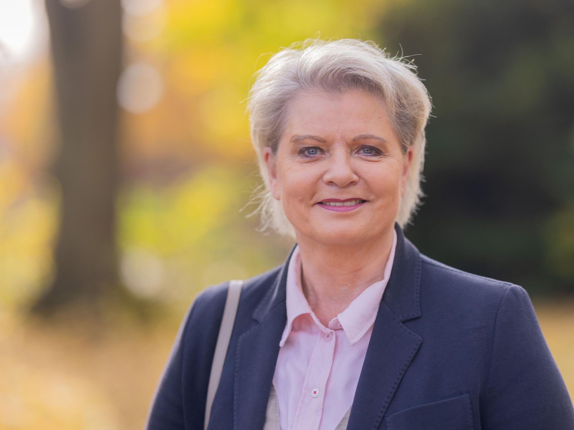 Andrea Spatzek steht in einem Park.