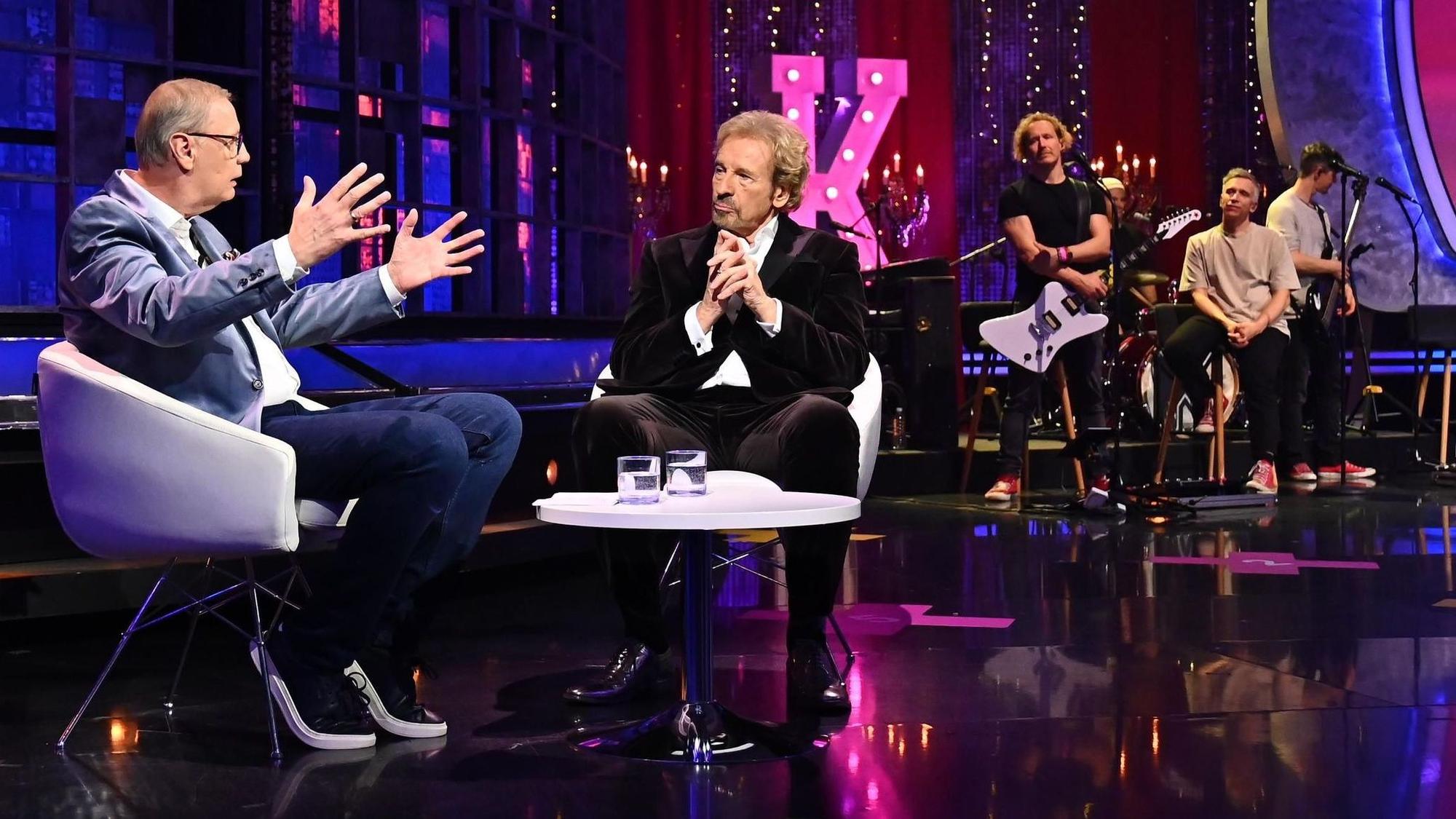 Günther Jauch spricht mit Thomas Gottschalk im TV-Studio. Im Hintergrund ist die Band Kasalla.