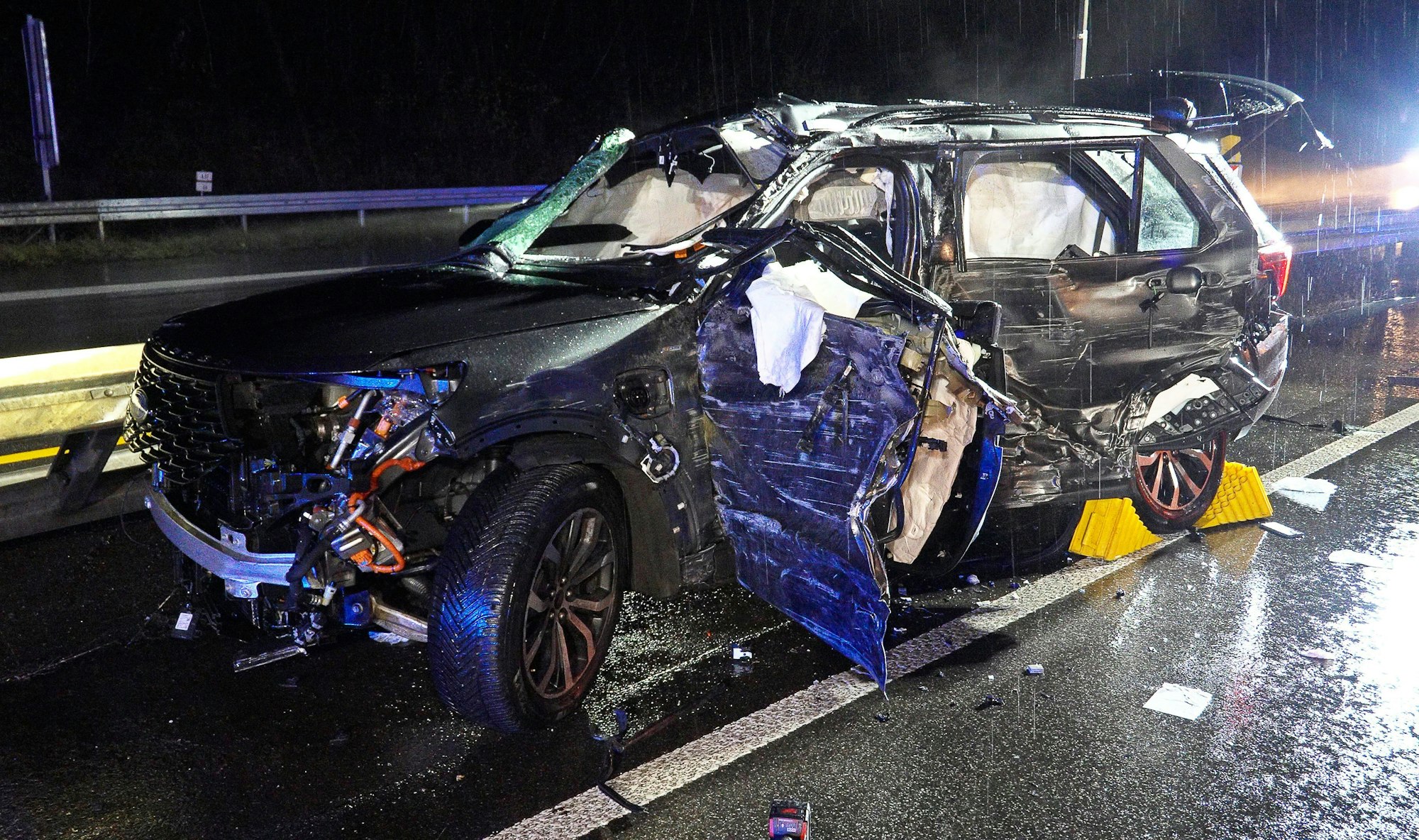 Ein beschädigtes Fahrzeug steht bei Regenwetter an der Unfallstelle auf der A8 zwischen Merchweiler und dem Kreuz Saarbrücken. Bei dem Unfall sind ein 46-Jähriger und seine 13 Jahre alte Tochter ums Leben gekommen, wie die Polizei mitteilte.