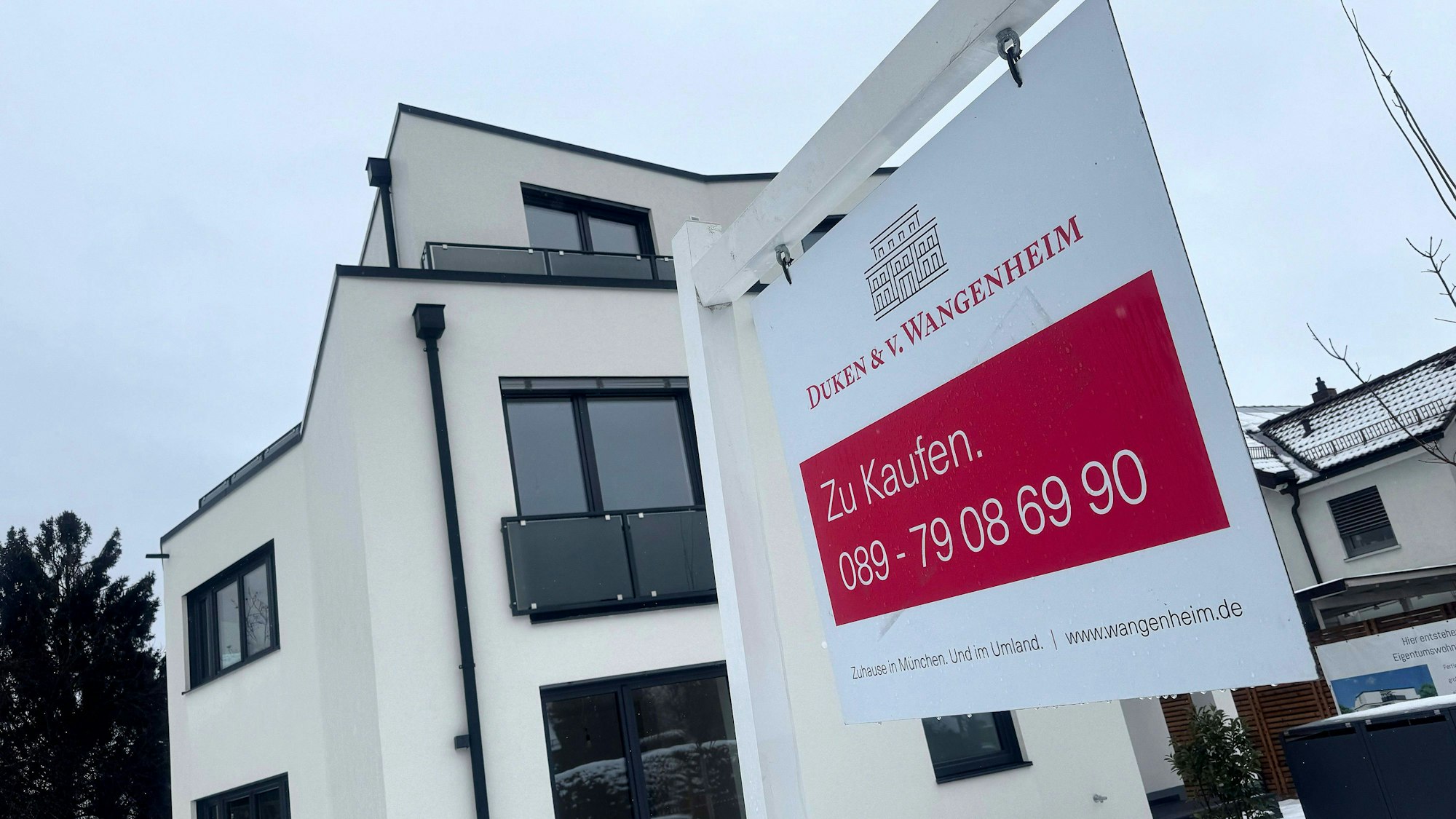 Neubau-Immobilie mit Schild "Zu Kaufen" in München (Symbolbild)