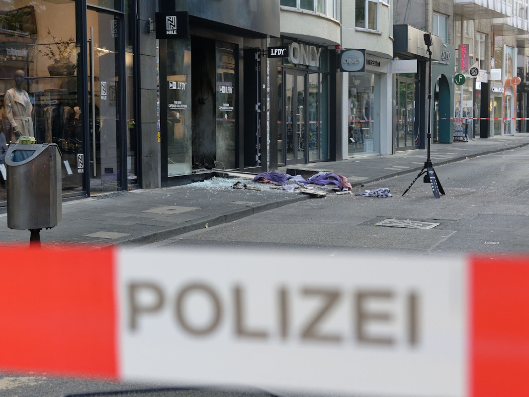 Scherben und Kleidungstücke liegen vor einem Geschäft in der Ehrenstraße in Köln. Jetzt startet der Prozess gegen den mutmaßlichen Boss im Kölner Drogenkrieg.