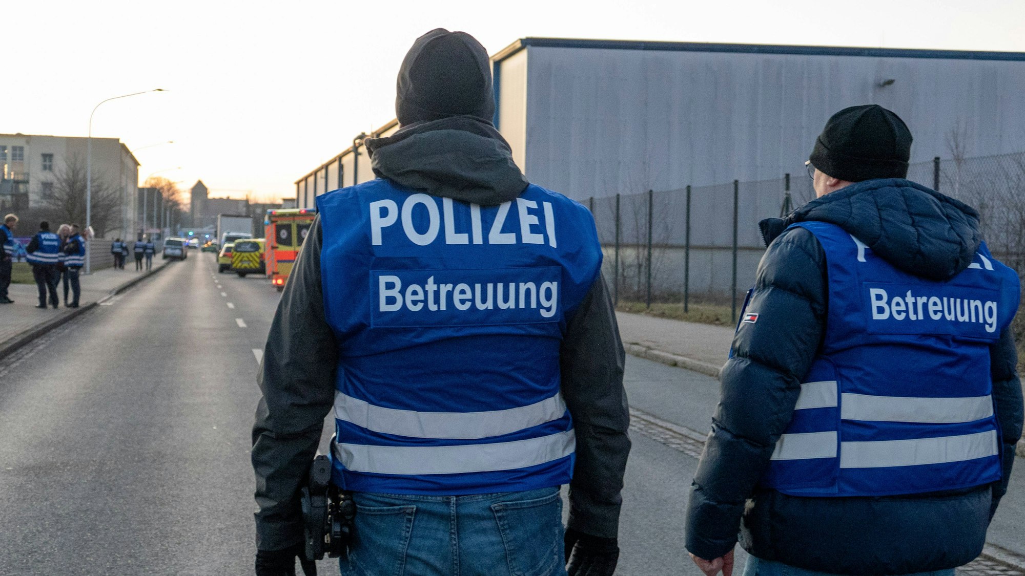 Zwei Polizisten mit blauen Westen auf der Straße