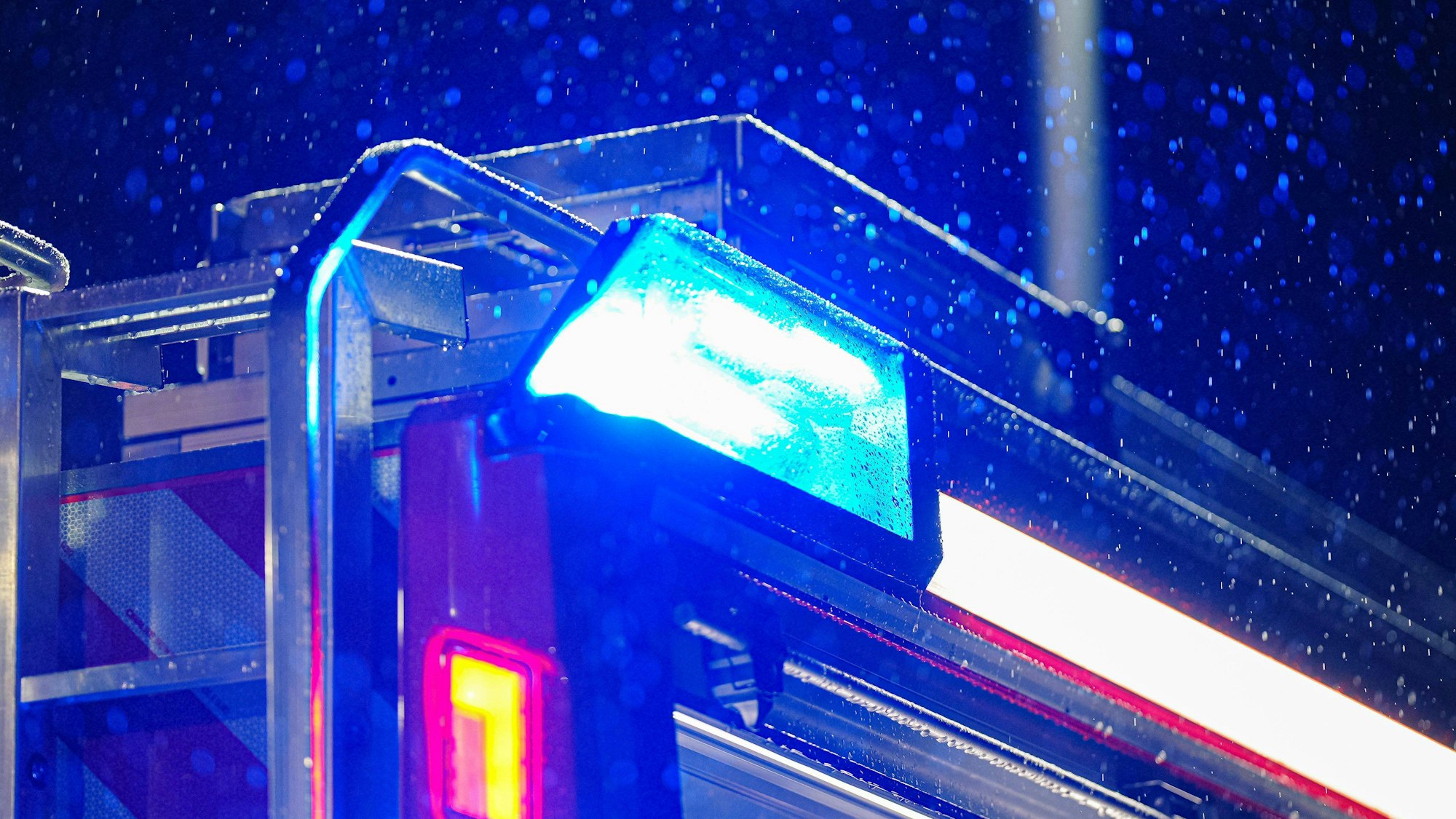Symbolfoto: Blaulicht auf Feuerwehrauto bei Regen