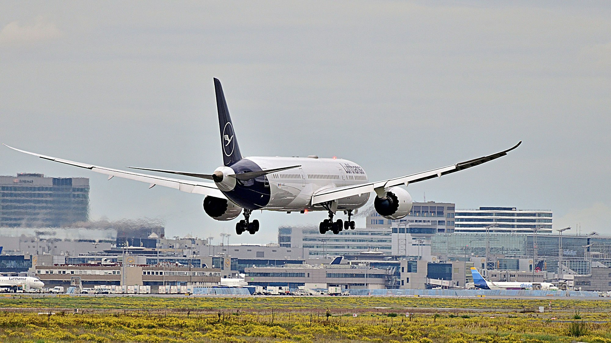 Passagierflugzeug landet auf Flughafen mit Gebäuden im Hintergrund