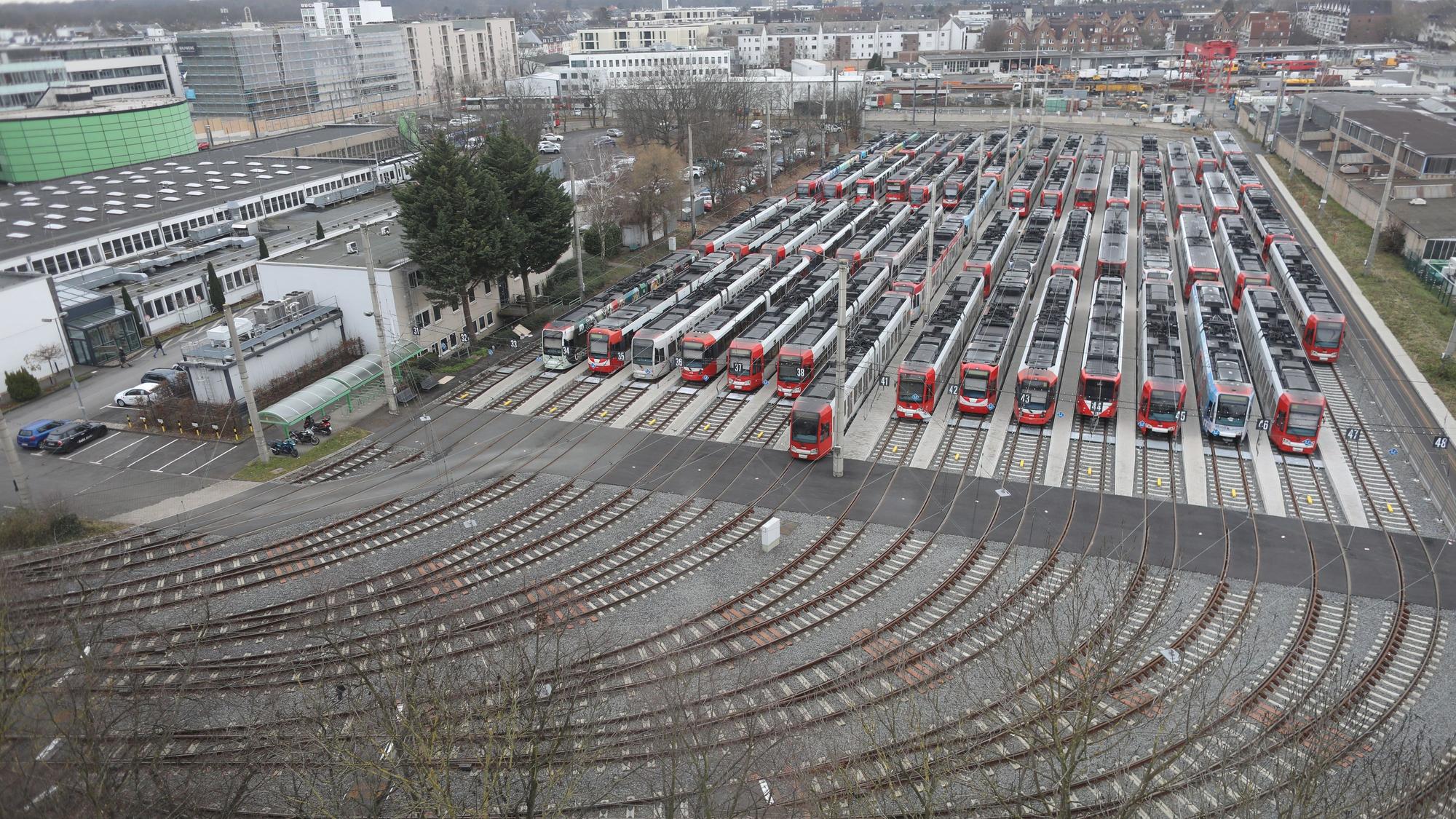 Rund zehn Bahnen stehen still nebeneinander auf Gleisen.