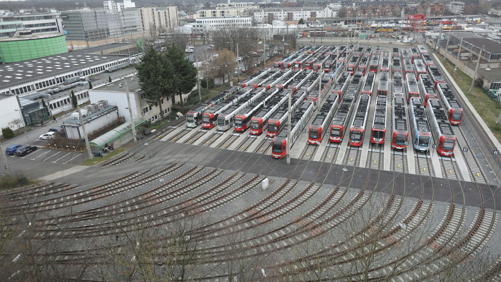 Rund zehn Bahnen stehen still nebeneinander auf Gleisen.