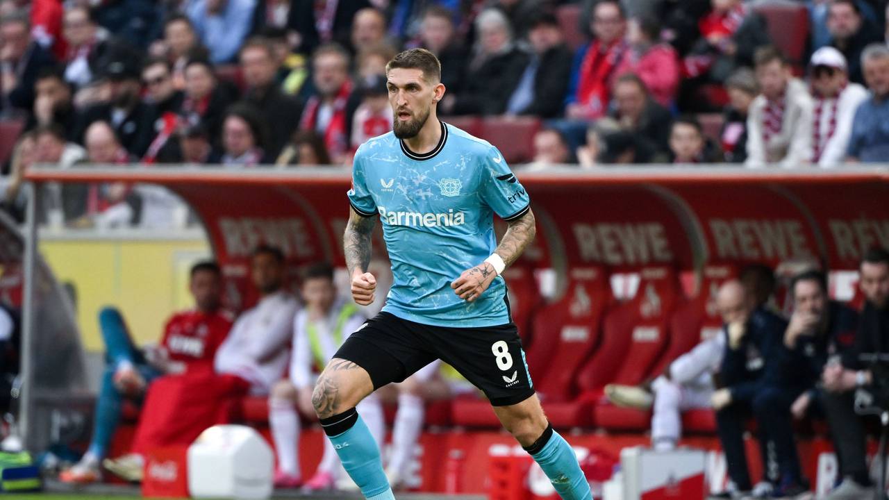 Robert Andrich dribbelt mit dem Ball, im Hintergrund sieht man die Auswechselbank des 1. FC Köln.
