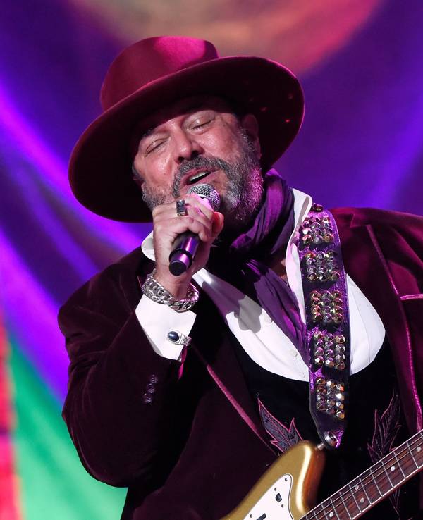Raul Malo bei einem Auftritt, er hat eine Gitarre umgehängt und singt mit geschlossenen Augen in ein Mikrofon.