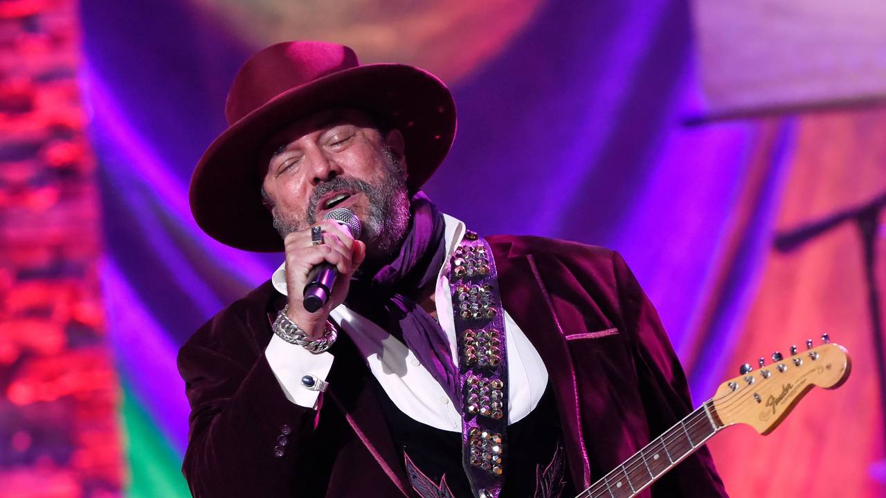 Raul Malo bei einem Auftritt, er hat eine Gitarre umgehängt und singt mit geschlossenen Augen in ein Mikrofon.