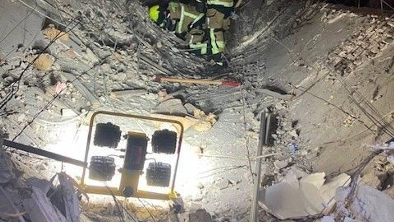 Ein Feuerwehrmann der Feuerwehr Oberhausen steht auf einer eingestürzten Decke eines Ladenlokals.