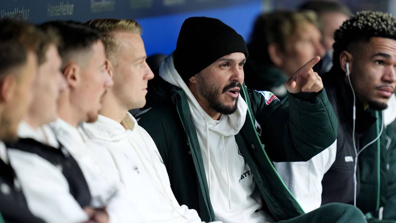 Leonardo Bittencourt sitzt auf der Auswechselbank und zeigt etwas.