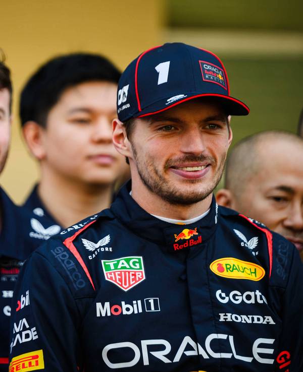 Dr. Helmut Marko und Max Verstappen stehen bei einem Team-Foto nebeneinander und blicken in die Kamera.