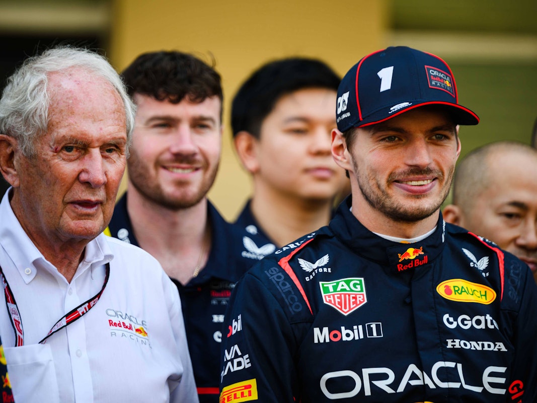 Dr. Helmut Marko und Max Verstappen stehen bei einem Team-Foto nebeneinander und blicken in die Kamera.