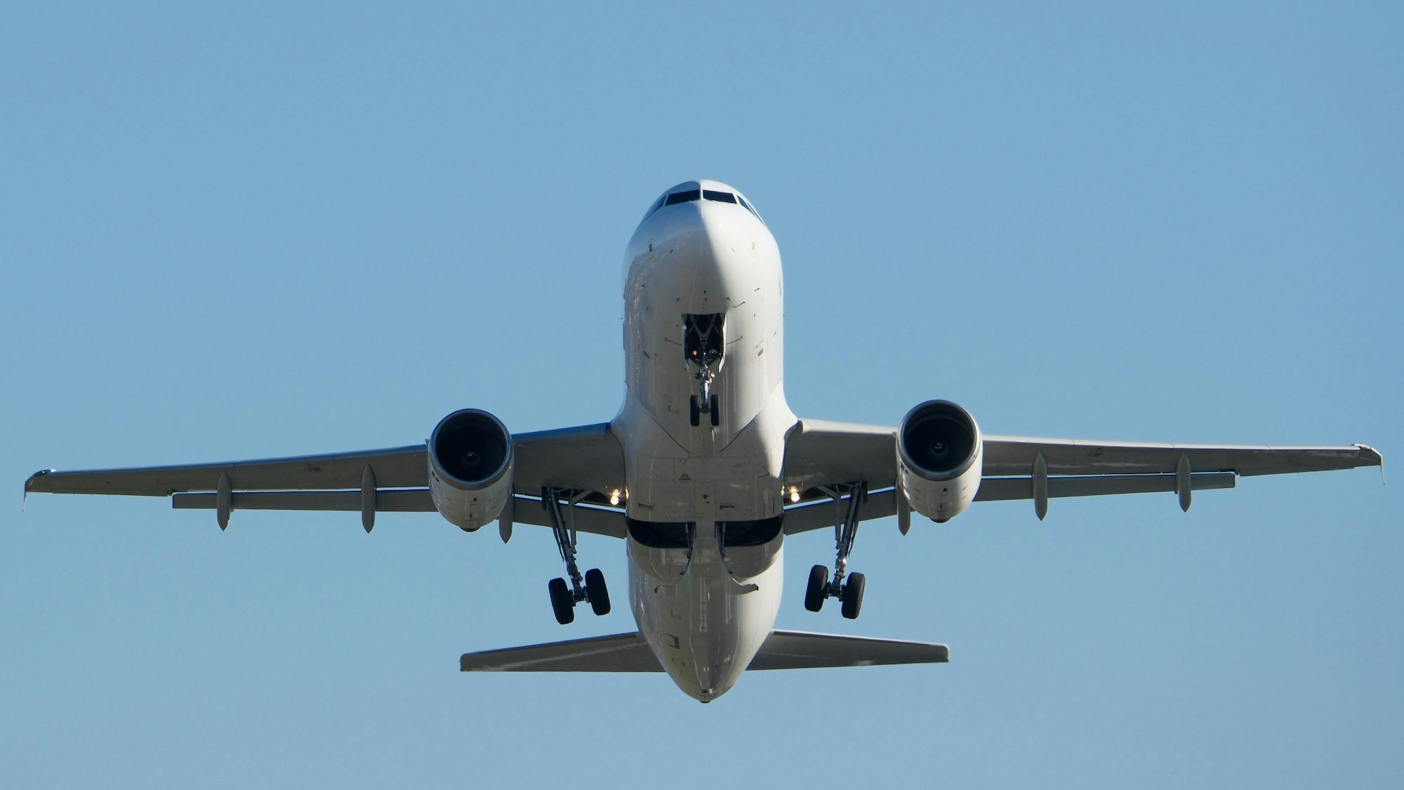 Ein weißes Flugzeug hebt vor blauem Himmel ab (Symbolbild)