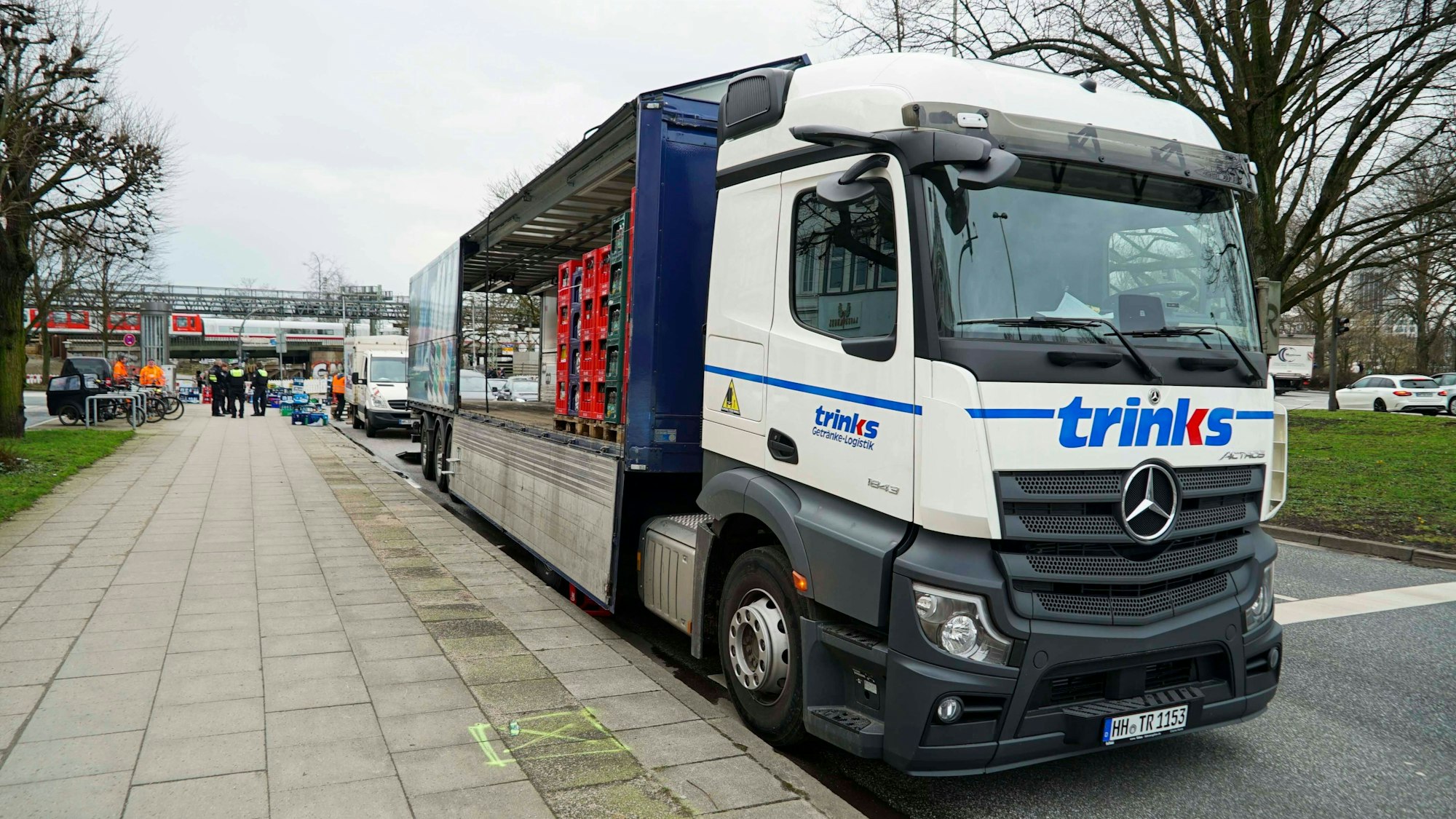 Lkw verliert Ladung, Menschen helfen beim Aufräumen