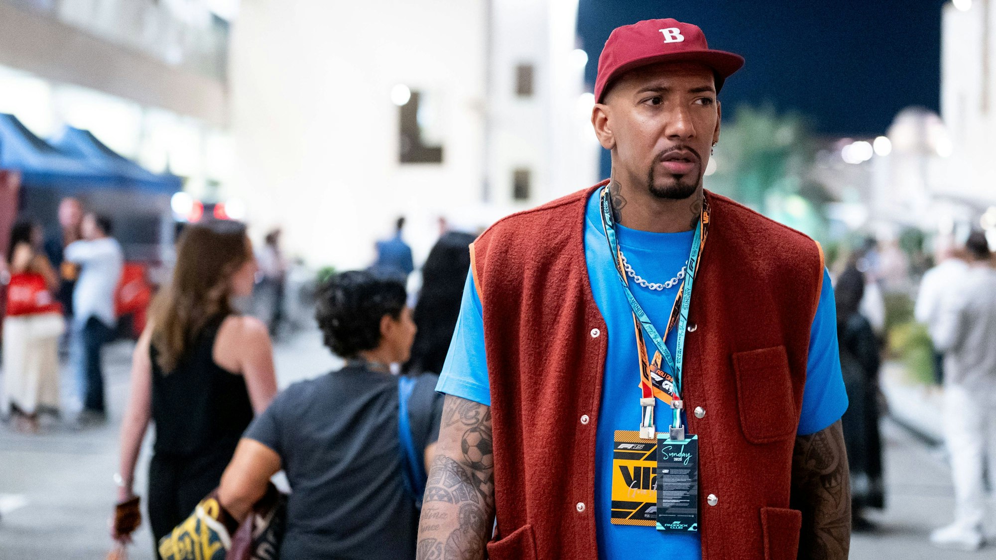 Ex-Fußball-Profi Jerome Boateng trägt ein blaues T-Shirt mit einer roten Weste und einer roten Jacke.