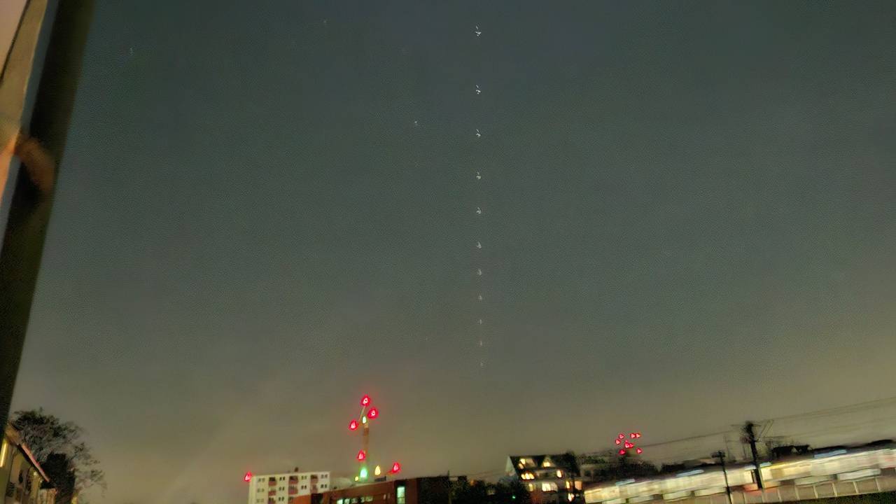 Zahlreiche Lichter, wie auf eine Kette gefädelt, sind am Himmel.